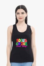 A woman with long dark hair is wearing the "Inspirational Tank Top for Women & Girls" from Looga, featuring vibrant text that says "Focus on the Good Things." She stands against a plain white background.