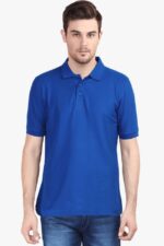 A man in a blue Polo T Shirt for men made from premium cotton stands against a white background, exuding a laid-back vibe. With its three-button placket capturing attention effortlessly, the solid color polo embodies the easygoing style of the looga trend, his hands relaxed at his sides.