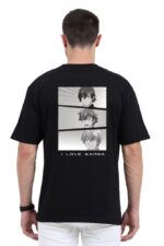 A person with short hair is wearing a Looga unisex oversized anime T-shirt featuring a black and white manga-style illustration of three characters on the back, under which the text I LOVE MANGA is displayed. The person is facing away from the camera.