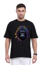 A man dressed in a black Unisex Oversized Classic T-Shirt featuring a vibrant, abstract gorilla face design stands against a plain white backdrop. Paired with his white pants and watch on his left wrist, he projects a sleek, Looga vibe.
