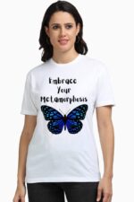 A person radiates confidence and inner strength while wearing the "Stylish and Empowering Women T-Shirt" from Looga, featuring a white design with a blue butterfly graphic and the inspiring words "Embrace Your Metamorphosis," reminiscent of a character from an enchanting looga narrative.