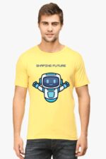A man with short brown hair wears a Looga unisex T-shirt featuring an AI-inspired design. The yellow T-shirt showcases a joyful blue and white cartoon robot with outstretched arms and the text SHAPING FUTURE, capturing the essence of innovation. He stands calmly, wearing a neutral expression.