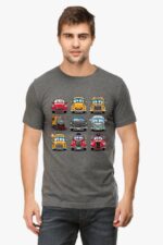 A man with short brown hair and a beard wears a Looga Cartoon Cars T-shirt, featuring colorful, animated vehicle faces like cars and trains in rows, adding charm to his ensemble.