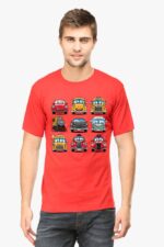 Sporting a Cartoon Cars T-shirt from Looga, featuring smiling car illustrations in three rows on a red background, an individual with short hair pairs the fun and quirky look with jeans against a plain backdrop.