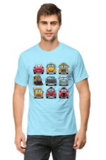 A man with short hair wears a Looga light blue Cartoon Cars T-shirt showcasing colorful cartoon vehicles like cars, buses, and a train in a grid pattern against a white background.