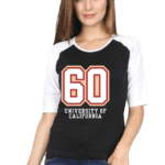 A woman with long hair is wearing a black and white raglan t-shirt featuring the number 60 and the words University of California. She is also wearing blue jeans and standing against a plain background.