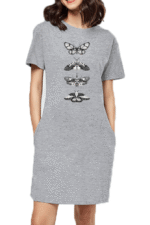 A woman wears a gray t-shirt dress by Looga, featuring four stacked black and white butterflies and moths. The short-sleeve dress combines mystique with practicality, offering stylish pockets.