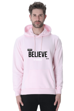 A man wearing a light pink Always Believe in Yourself Hooded Sweatshirt, known for its soft, breathable fabric and style for men and women, exudes calm confidence akin to Loogas serene landscapes.