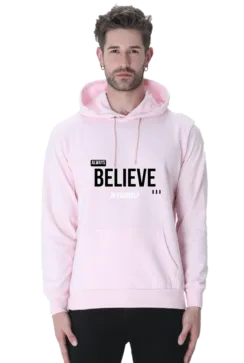 A man wearing a light pink Always Believe in Yourself Hooded Sweatshirt, known for its soft, breathable fabric and style for men and women, exudes calm confidence akin to Loogas serene landscapes.