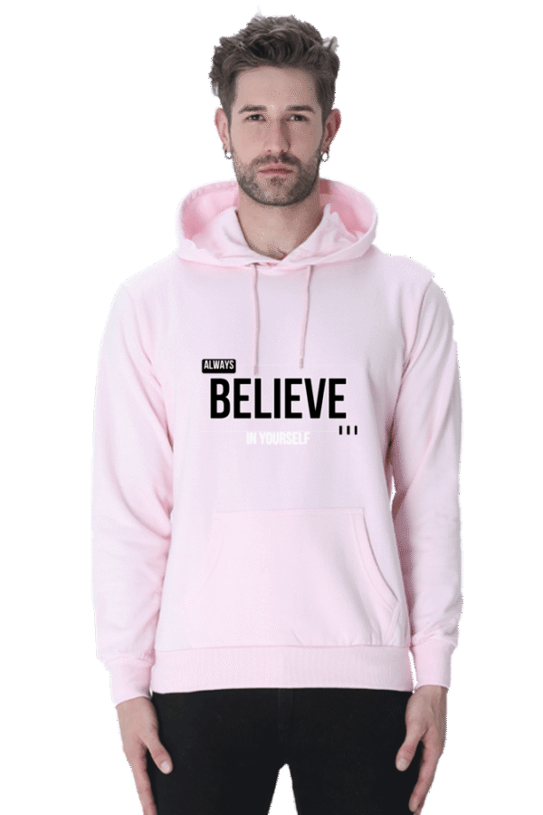 A man wearing a light pink Always Believe in Yourself Hooded Sweatshirt, known for its soft, breathable fabric and style for men and women, exudes calm confidence akin to Loogas serene landscapes.