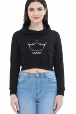 A person confidently stands against a plain background, wearing a black Trendy Crop Hoodie with a crown and QUEEN design. Their long hair and hoop earrings complement the look, paired with blue jeans for a laid-back, stylish Looga-inspired vibe.