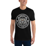 Wearing a Looga Black T-Shirt for Bikers, featuring a biker graphic with handlebars and BIKERS GO AT YOUR HEART, a person stands smiling against a white background, exuding undeniable style.
