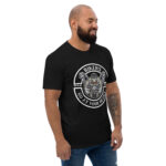 A man in a Looga Black T-Shirt for Bikers with a thematic graphic reading Bikers go at your heart stands against a white backdrop. With a beard and blue jeans, his smile reflects the freedom of open roads, embodying the essence of the Looga spirit.