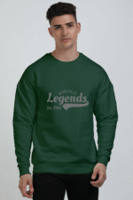 A person with short hair is wearing a cozy oversized bottle green sweatshirt featuring Borcelle Legends Est. 1950 on the front. The plain white background highlights their comfortable style.