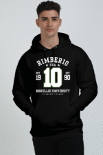 Wearing a black Heavy Cotton Hoodie with Rimberio USA, 10, Borcellec University, 1990 in white and green text with star accents, someone stands against a plain backdrop.