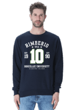 A man with short dark hair and a light beard wears the Navy Blue unisex sweatshirt featuring Rimberio USA 19 EST. 10 90 Borcellec University in white and green letters. He pairs it with light blue jeans, embodying the timeless Rimberio 1990 style.