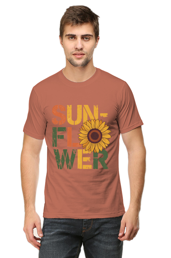 A man stands facing forward, wearing Product—a T-shirt with SUNFLOWER in bold, colourful letters and a large sunflower image replacing the O in FLOWER. A man stands facing forward, wearing Product—a T-shirt with SUNFLOWER in bold, colourful letters and a large sunflower image replacing the O in FLOWER.
