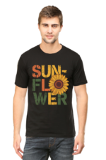 A man with short hair wears Product, a black T-shirt featuring "SUNFLOWER" in large, colourful letters with a sunflower graphic as the O, standing against a plain background.